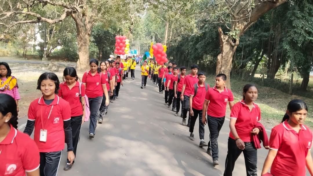 Students in red house shirts marching with balloons